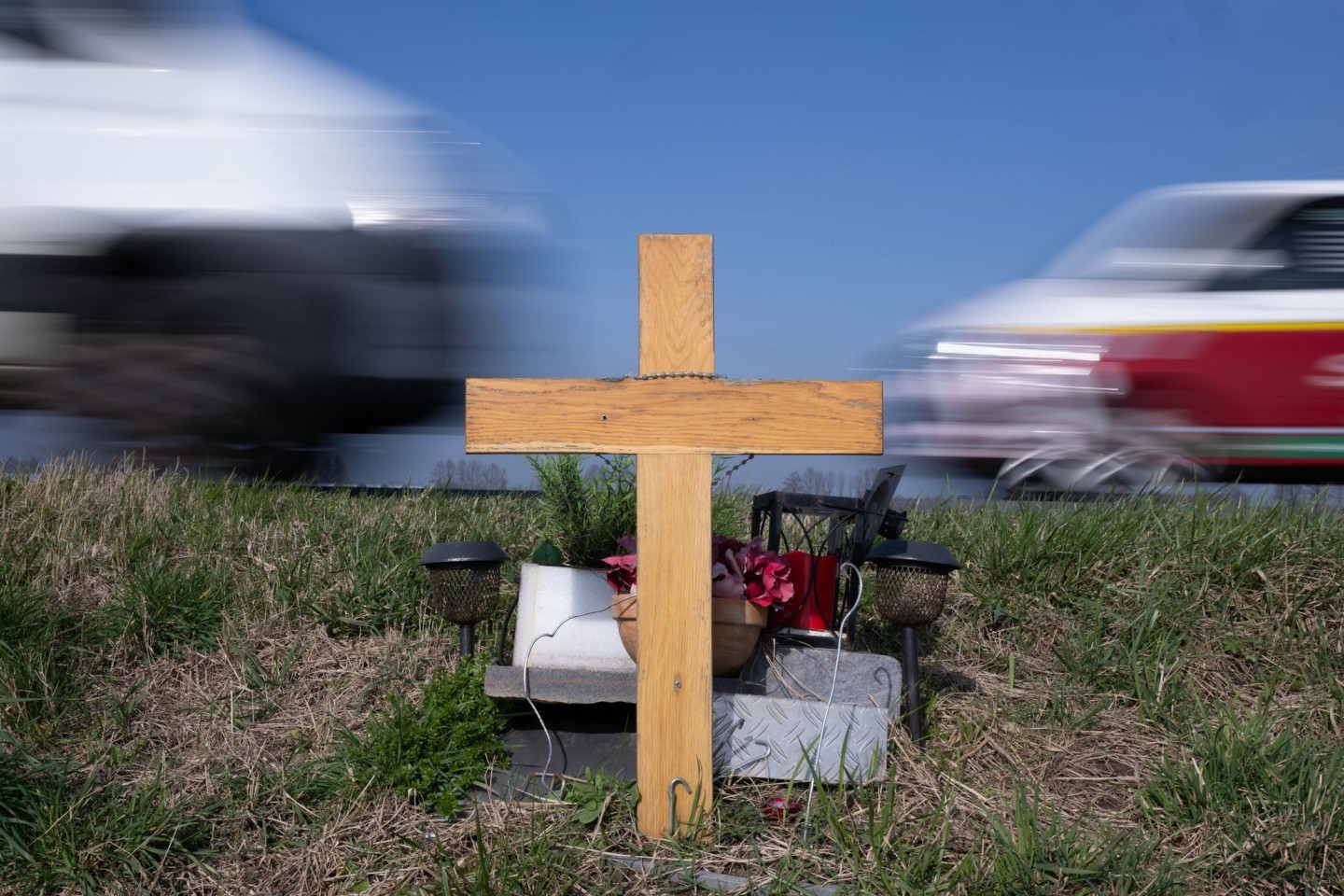Ein Holzkreuz erinnert an das Opfer eines Verkehrsunfalls.