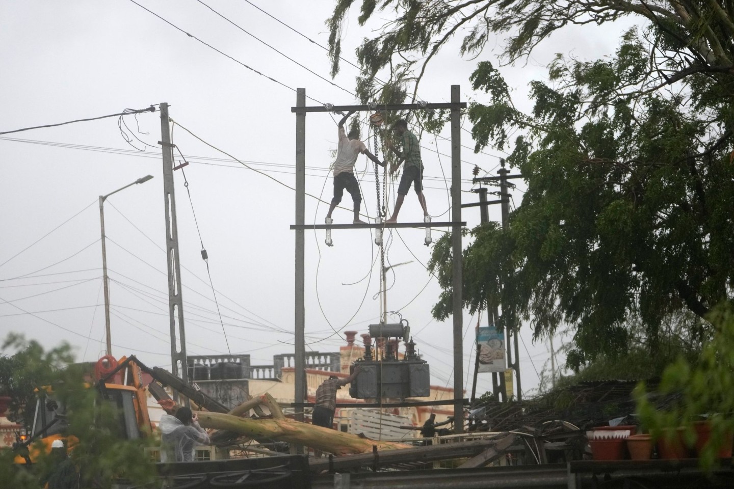 Arbeiter reparieren in Mandvi im indischen Bundesstaat Gujarat einen Transformator, um die Stromversorgung wiederherzustellen.
