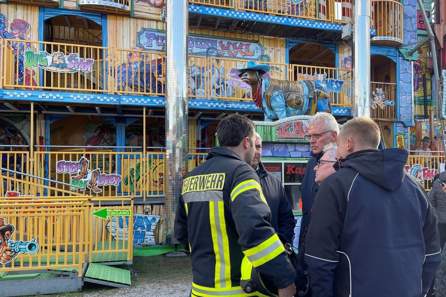 Feuerwehrleute und Polizisten stehen vor dem Funhouse auf dem Pollhansmarkt in Schloß Holte-Stukenbrock.