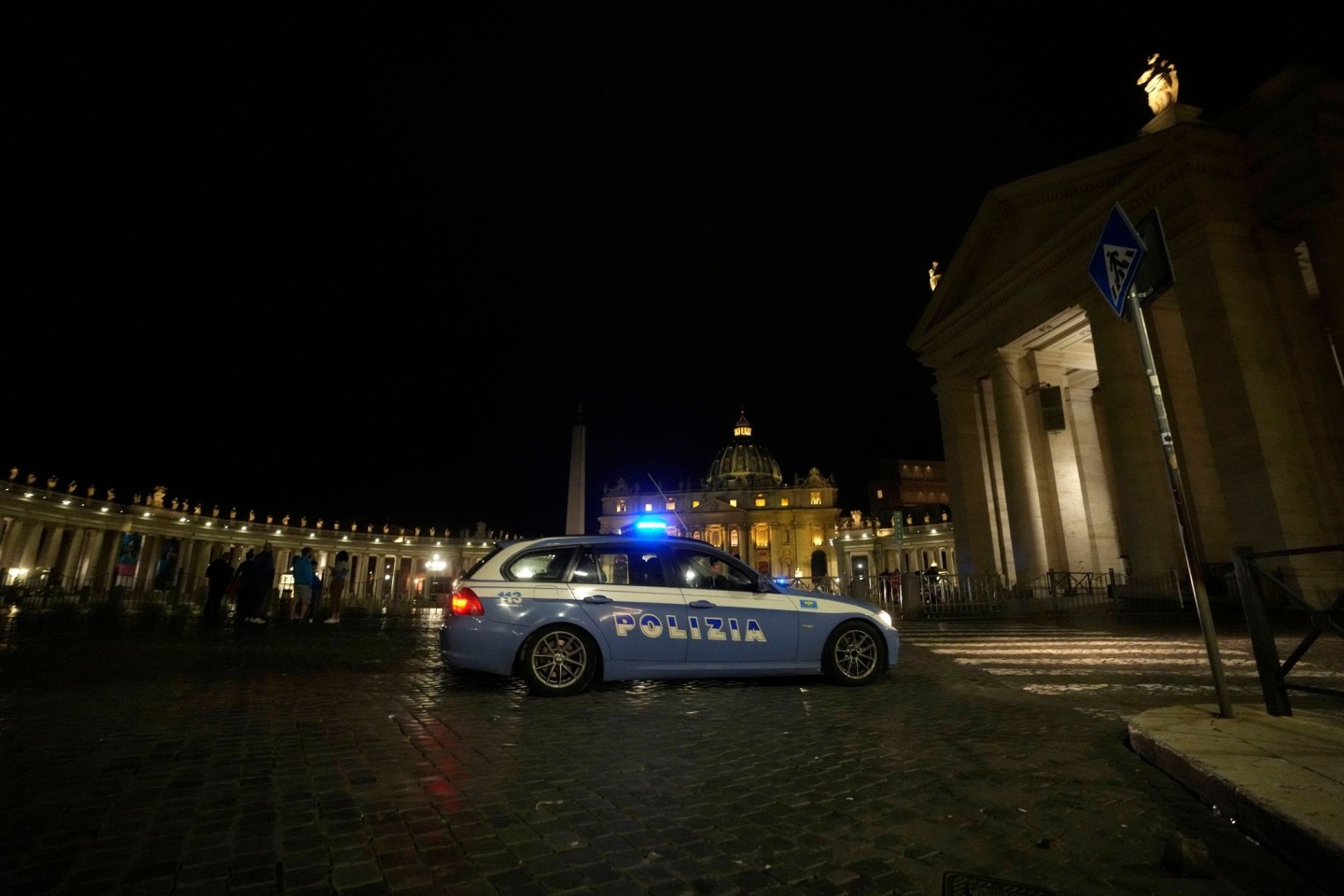 Ein italienisches Polizeiauto fährt am späten Abend vor dem Petersplatz im Vatikan vorbei.