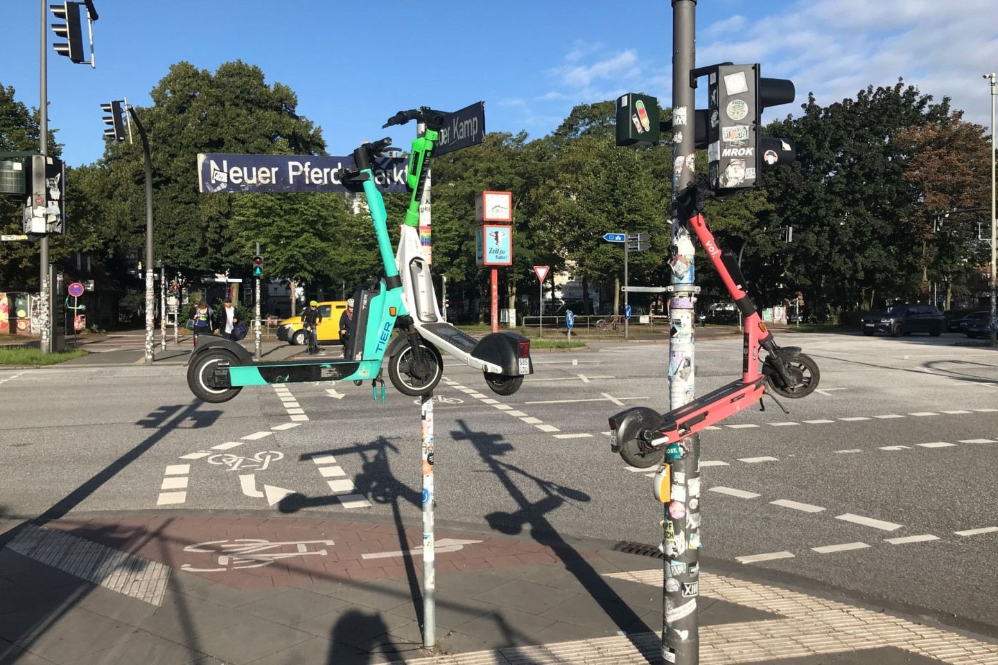 Drei E-Scooter hängen an Masten im Hamburger Stadtteil St. Pauli.