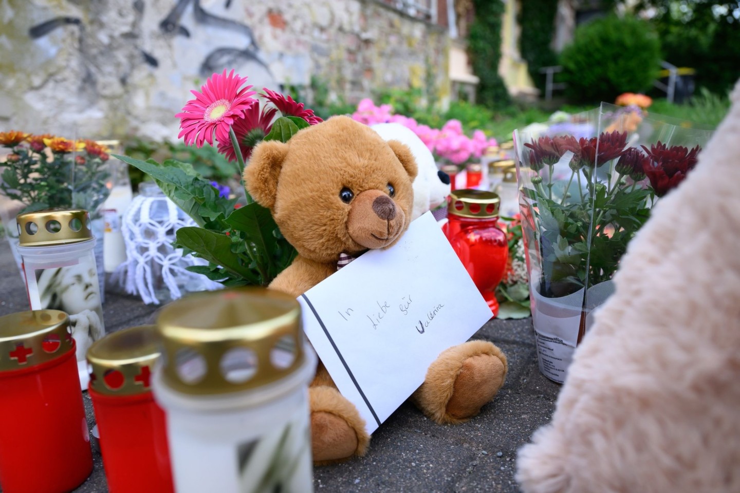 Ein Brief mit der Aufschrift «In Liebe für Valeriia», Teddybären, Blumen und Kerzen sind in der Nähe der Wohnung des getöteten Mädchens auf dem Fußweg abgelegt.