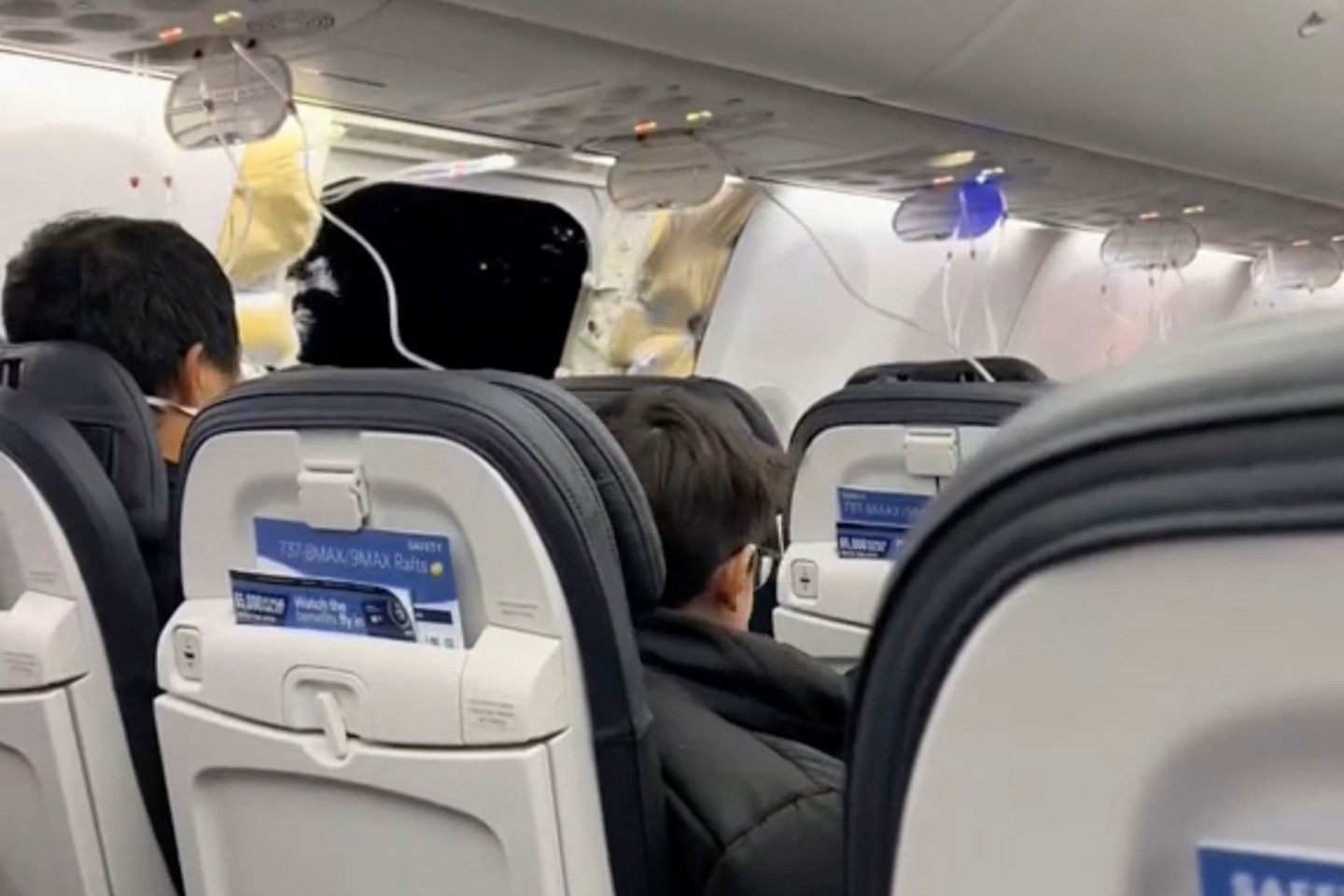 Passagiere sitzen in der Boeing 737-9 Max in der Nähe des abgerissenen Kabinenteils samt Fenster.