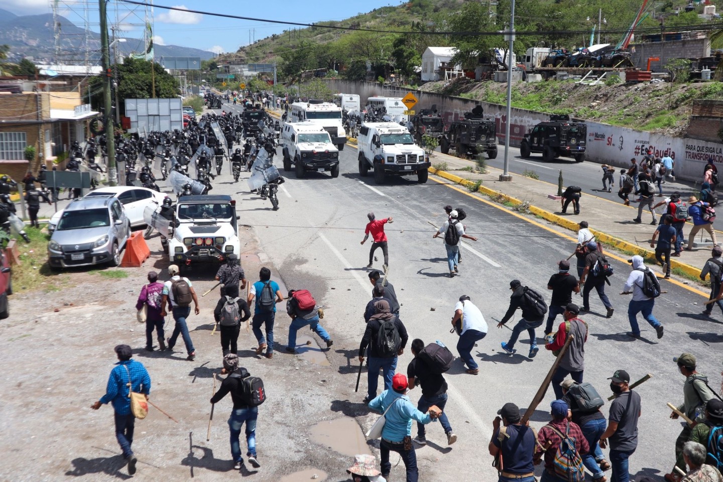 Sicherheitskräfte werden auf einer Autobahn in Chilpancingo von Demonstranten mit Steinen beworfen.