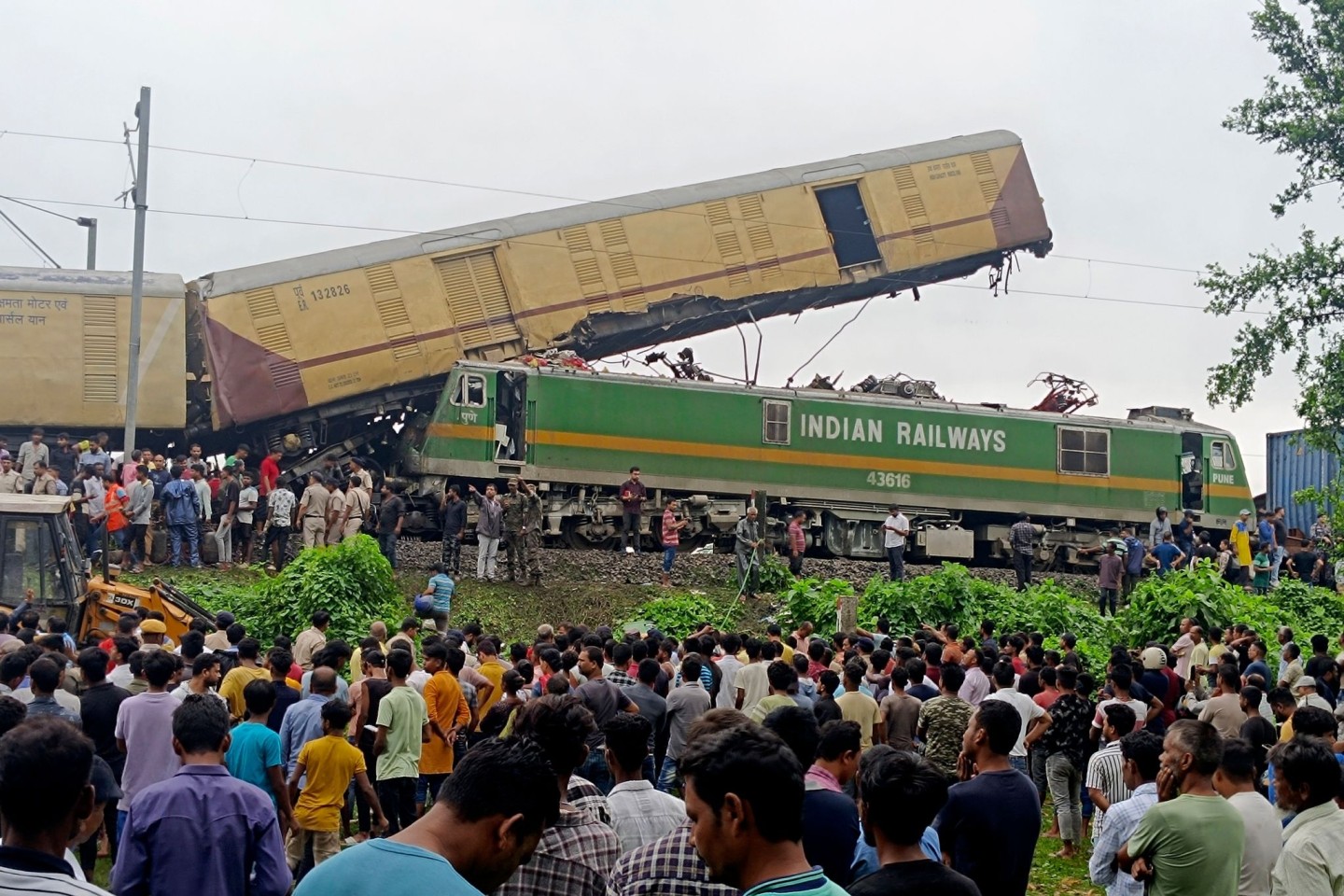 Schaulustige beobachten die Arbeit von Rettungskräften, nachdem ein Güterzug in der Nähe des Bahnhofs von New Jalpaiguri im indischen Bundesstaat Westbengalen einen Personenzug gerammt ha...