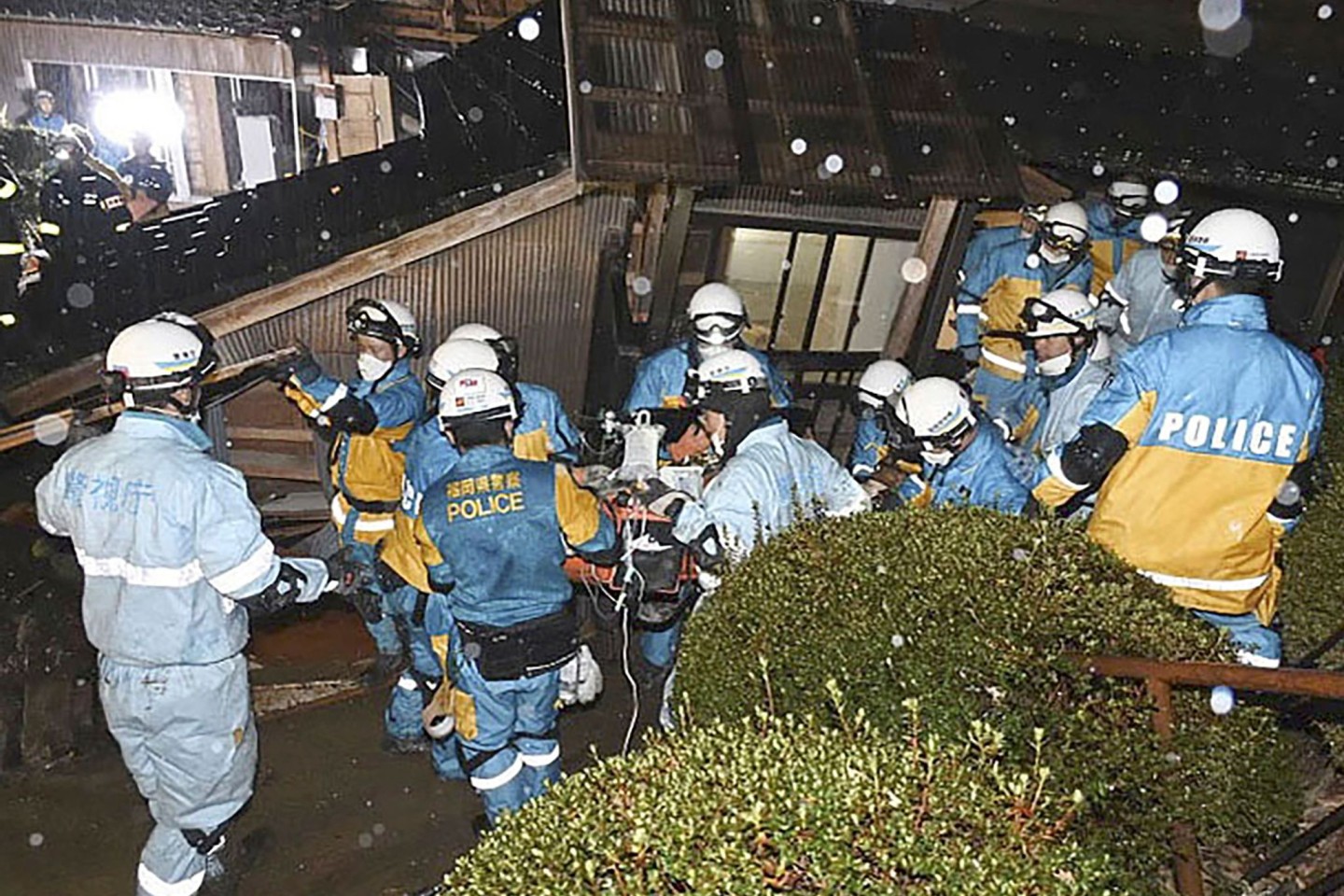 Polizisten retten im japanischen Suzu eine Frau aus einem eingestürzten Haus.