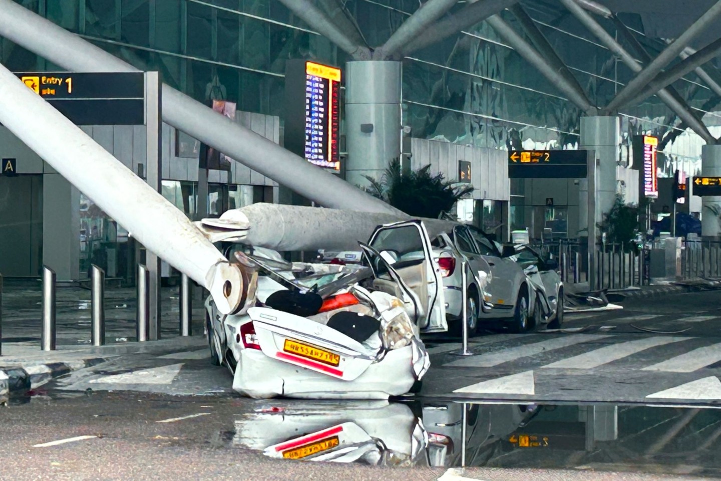 Autos sind durch den Einsturz einer Überdachung des Abflugterminals des Flughafens Indira Gandhi in Neu-Delhi beschädigt worden.