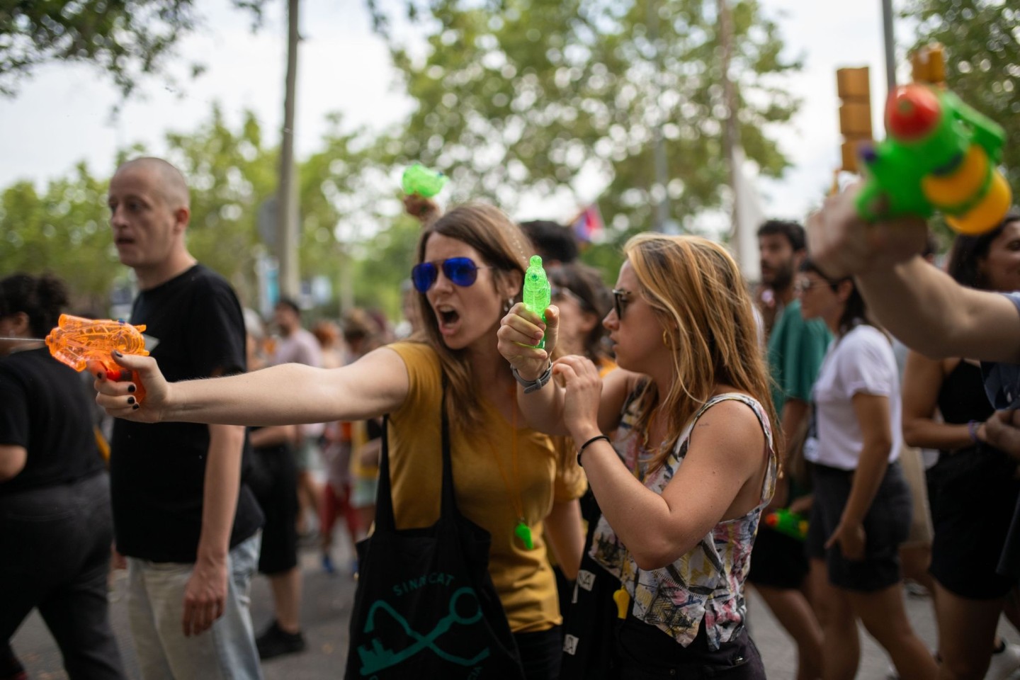 Demonstrantinnen verpassen Urlaubern eine unerbetene Abkühlung aus Wasserpistolen.