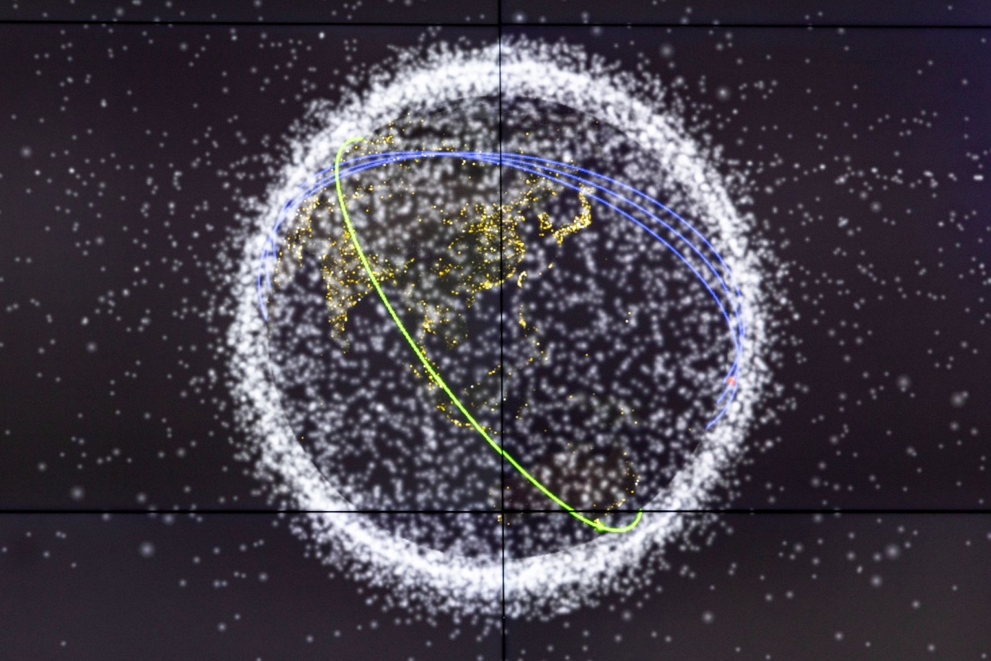 Auf einem Monitor wird die Flugbahn eines ausrangierten Batteriepakets der ISS um die Erde angezeigt.