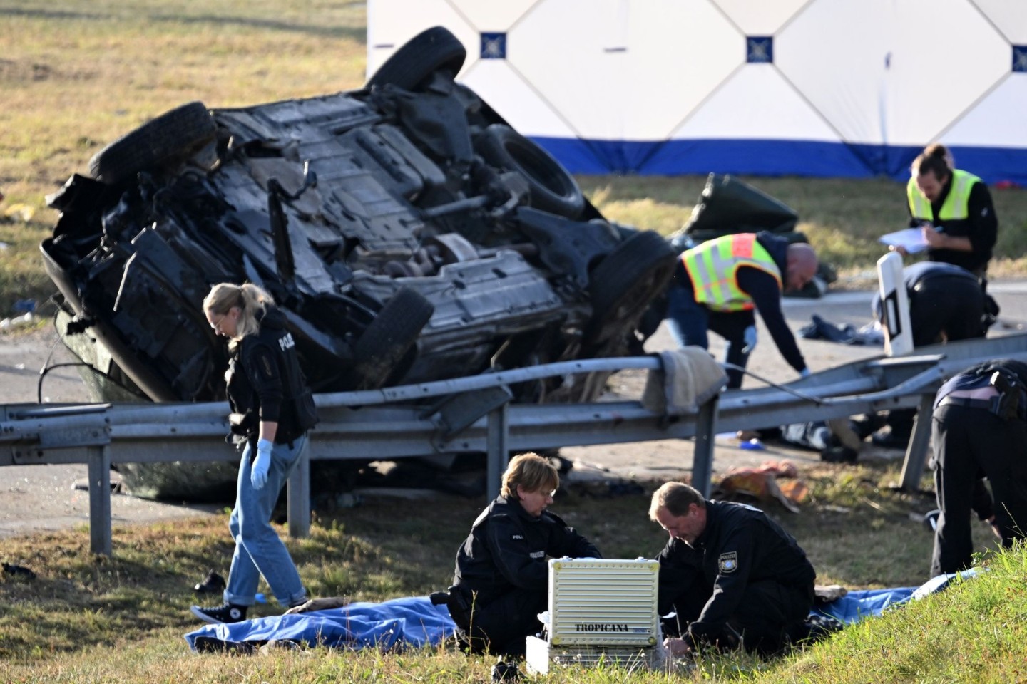 Rettungskräfte und Polizisten am umgestürzten Fahrzeug. Beim Unfall sind sieben Menschen gestorben und mehrere schwer verletzt worden.