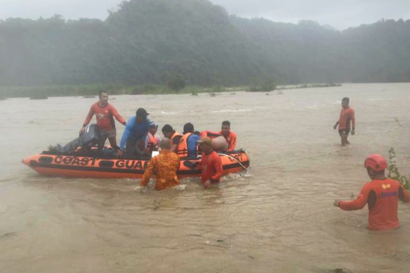 Steinbrucharbeiter werden in Naguilian (Philippinen) mit einem Schlauchboot evakuiert.