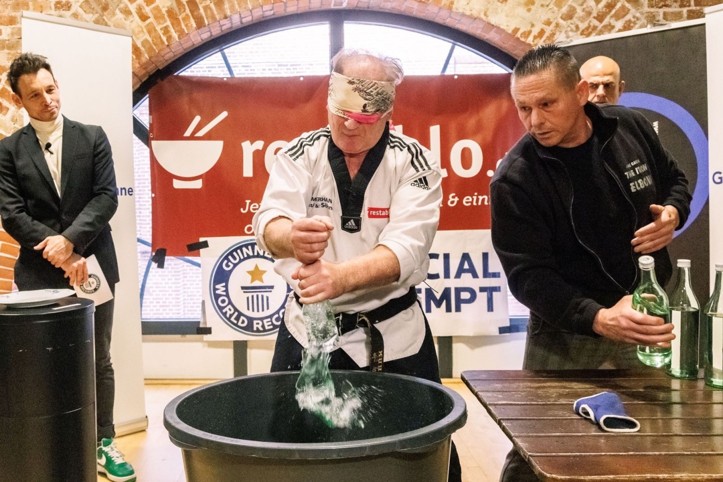 Der Kampfsportler Muhamed Kahrimanovic beim Versuch, mit verbundenen Augen und einem rohen Ei in der Hand Glasflaschen zu zerschlagen.